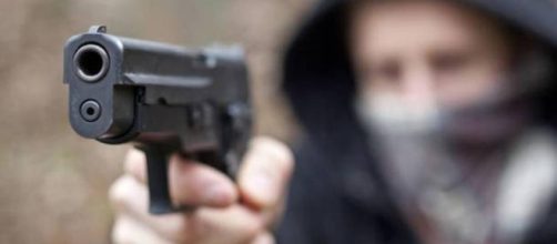 Un uomo compie una rapina armato di pistola, immagine di repertorio