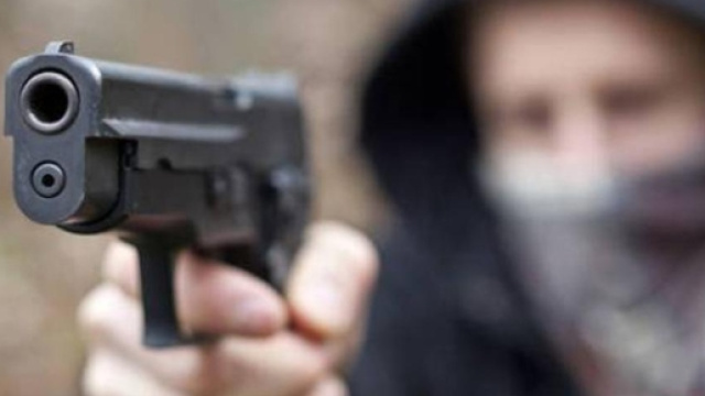 Un uomo compie una rapina armato di pistola, immagine di repertorio