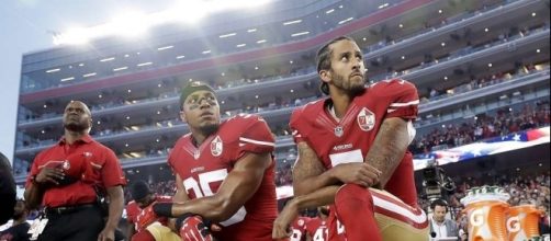 San Francisco 49ers' quarterback Colin Kaepernick (right) and safety Eric Reid kneel for the national anthem last year. (Photo: SFGate.com)
