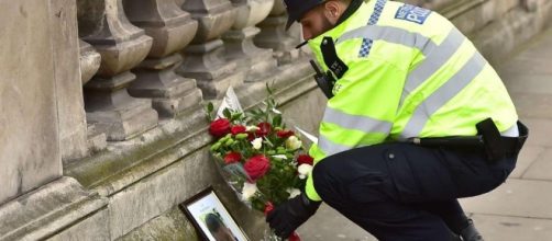 Fiori a Westminster davanti alla foto dell'agente ucciso (LaPresse)