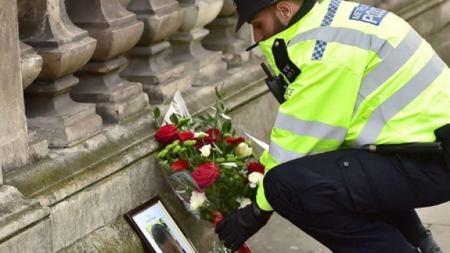Fiori a Westminster davanti alla foto dell'agente ucciso (LaPresse)