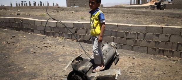 Un petit garçon joue sur un morceau d'obus qui a explosé près de son domicile - PHOTO: UNICEF/MOHAMED HAMOUD Un petit garçon joue sur un morceau d'obus qui a explosé près de son domicile - PHOTO: UNICEF/MOHAMED HAMOUD