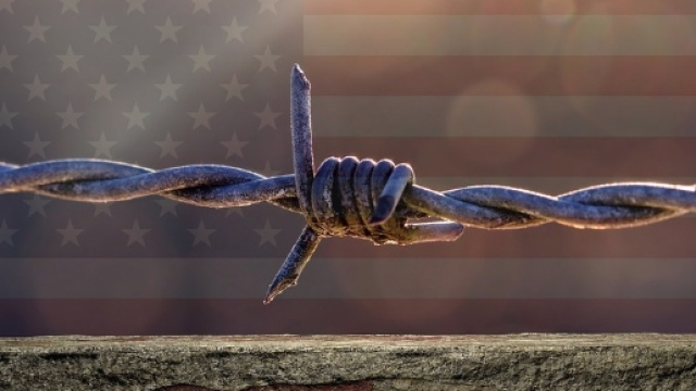 Filo spinato simbolico che già ricopre una parte di muro al confino con il Messico.