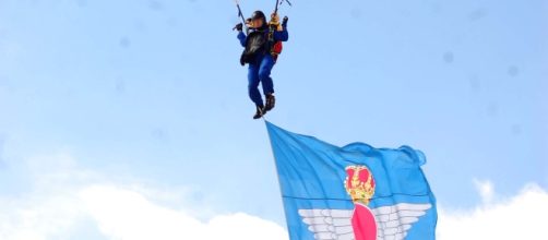 Paracaidista de la PAPEA desciende con la bandera del Ejército del Aire.