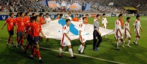 I giocatori delle due Coree entrano in campo reggendo la 'bandiera della riunificazione'