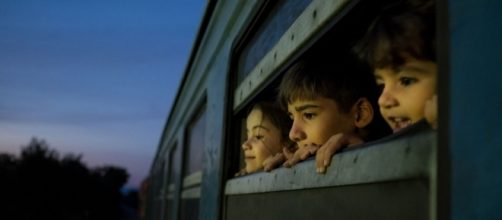 Tres pequeños refugiados de Siria, Afganistán e Iraq viajan a un centro para migrantes y refugiados. Cortesía Foto: UNICEF / Ashley Gilbertson