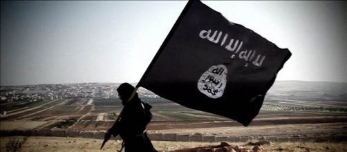 Un combattente jihadista con la bandiera dell'Isis
