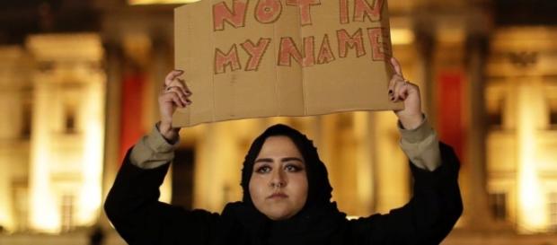 A Muslim woman holds a sign ... - go.com A Muslim woman holds a sign ... - go.com