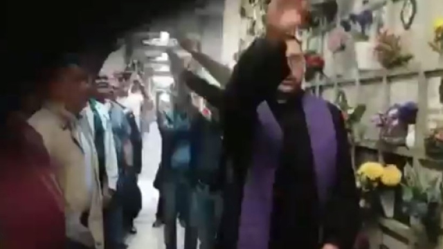 Don Amendola, cappellano dei camerati, fa il saluto fascista nel commemorare al cimitero di Milano un rapinatore squadrista morto 40 anni fa.