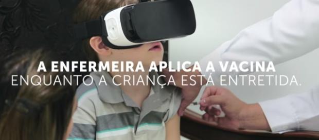 A enfermeira aplica a vacina enquanto a criança está entretida A enfermeira aplica a vacina enquanto a criança está entretida