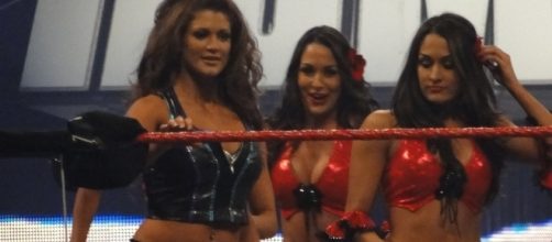 Former WWE Divas champions Eve Torres and The Bella Twins appear in ring together. [Image via Wikimedia Commons]