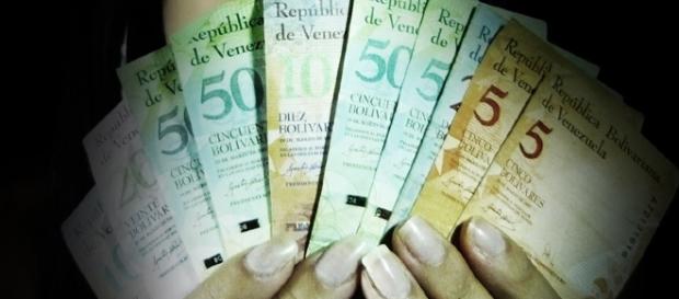 En la imagen, una mujer con billetes en la mano desplegados En la imagen, una mujer con billetes en la mano desplegados