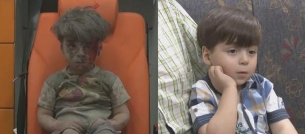 Menino de Aleppo resgatado com o rosto sujo de sangue, revê a própria imagem em um celular. Menino de Aleppo resgatado com o rosto sujo de sangue, revê a própria imagem em um celular.
