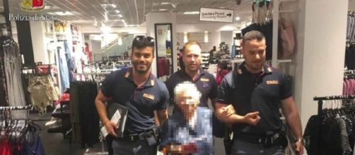 La nonnina esce dai magazzini dove aveva rubato un profumo 'scortata' da tre agenti della polizia di Stato.