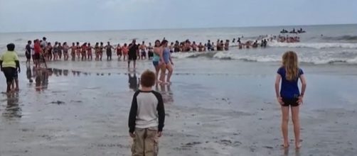 Photo human chain rescues family caught in riptide screen capture via YouTube/The Last News