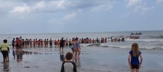 Dozens of strangers form human chain to rescue swimmers at Florida beach (Image Credit: The Last News/Youtube) Dozens of strangers form human chain to rescue swimmers at Florida beach (Image Credit: The Last News/Youtube)