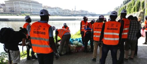 Migranti volontari raccolgono rifiuti