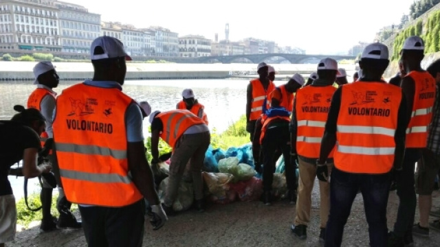 Migranti volontari raccolgono rifiuti