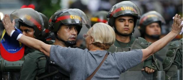 Una mujer se enfrenta a un Guardia Nacional durante una protesta en Caracas, Venezuela. Una mujer se enfrenta a un Guardia Nacional durante una protesta en Caracas, Venezuela.