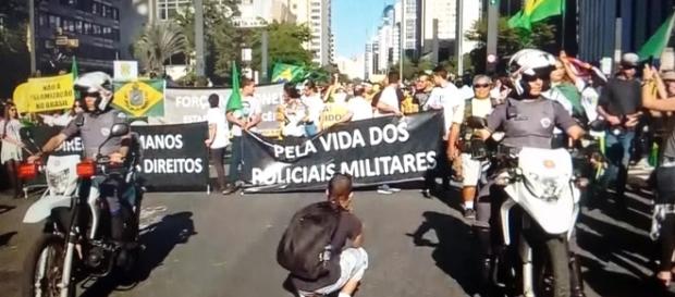 Grupo protesta contra morte de PMs e pede intervenção militar (Foto: Captura de vídeo/TV Globo) Grupo protesta contra morte de PMs e pede intervenção militar (Foto: Captura de vídeo/TV Globo)