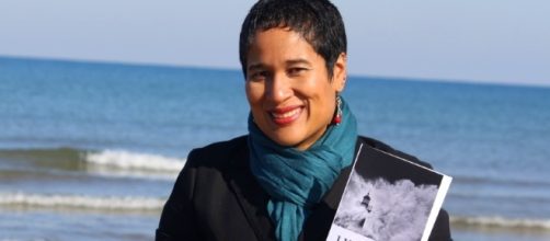 la scrittrice e attivista politica Ilka Corado mostra sorridendo uno dei suoi libri