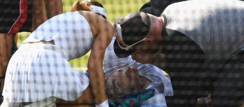 Bethanie Mattek-Sands (center) being tended to after knee injury during match with Sorana Cirstea (left). / [Image source: Youtube Screen grab]