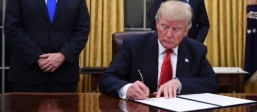 President Donald Trump photographed signing the executive order regarding travel ban - Flickr/carolbrunette7