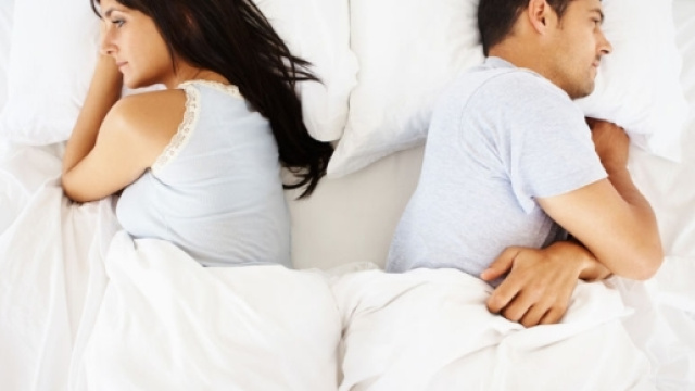 Una coppia a letto insieme sotto le coperte