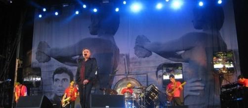 Morrissey on stage with band - photo by Alexander via Wikimedia Commons.