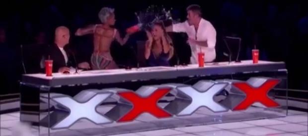 Not again: Another crude remark from Simon gets him splashed by Mel B on 'AGT.' / from 'YouTube' screengrab - www.youtube.com/watch?v=To6ykW9xYHE Not again: Another crude remark from Simon gets him splashed by Mel B on 'AGT.' / from 'YouTube' screengrab - www.youtube.com/watch?v=To6ykW9xYHE