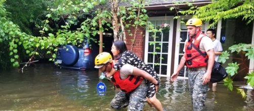 A National Guardsman carries an evacuee to safety. [Image via US Department of Defense]