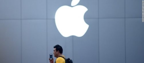 A Chinese man talks on his IPhone in front of an Apple store