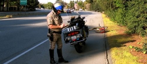 A California police officer held at gun on a car's passenger for 9 minutes [Image: Wikimedia by AkosSzoboszlay/Public Domain]