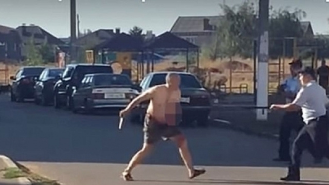 L'uomo che ha decapitato la nipote, mentre minaccia i poliziotti con il coltello.