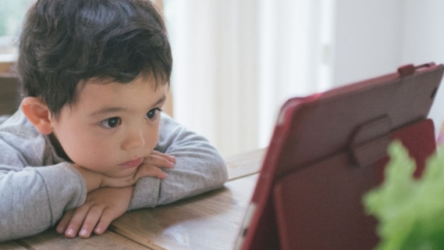 Bambino guarda cartone animato su un tablet.