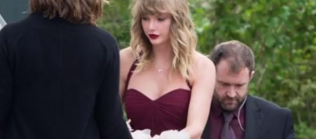 Taylor Swift attended best friend's wedding in burgundy maxi dress. YouTube/nICE TUBE Taylor Swift attended best friend's wedding in burgundy maxi dress. YouTube/nICE TUBE