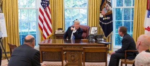President Trump getting briefed about Hurricane Harvey / [Image by The White House via Flickr, cropped, Public Domain]