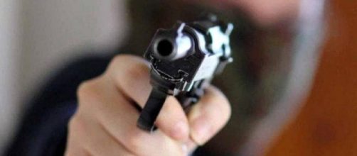 Un rapinatore con in mano la pistola