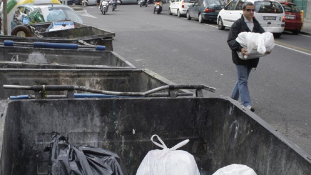 Il padre mentre getta il neonato nel cassonetto