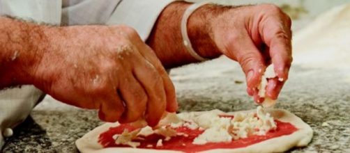 Un pizzaiolo prepara una pizza