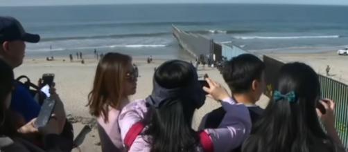 US reinforces border wall in Tijuana as migrants look on. [Image source/AFP News Agency YouTube video]