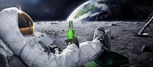 In alto, astronauta intento a bere una birra