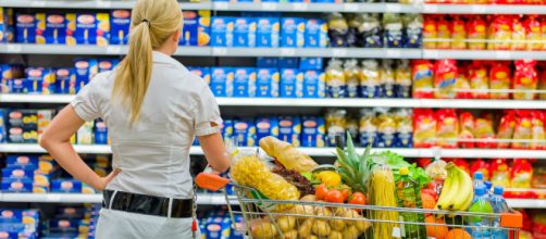 Una consumatrice difronte gli scaffali del supermercato. Le confezioni possono diventare ingannevoli: il prezzo è uguale ma la quantità è minore