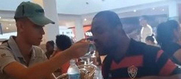 Funcionário ajuda homem com deficiência e gera polêmica (Captura de vídeo) Funcionário ajuda homem com deficiência e gera polêmica (Captura de vídeo)