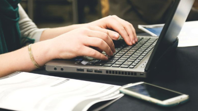 Una ragazza mentre scrive davanti al computer