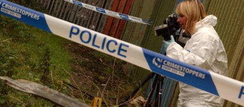 British police officer examining a crime scene (Photo via West Midlands Police - Flickr)