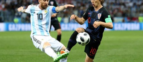 Modric, talento croato, impegnato in un contrasto con Lionel Messi.