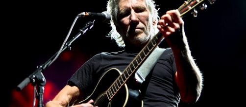 Roger Waters in concerto mentre suona la chitarra acustica
