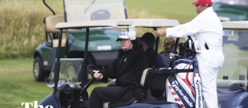 Trump at the golf course waving to protestors- Photo-( Image credit-the Guardian/youtube.com)