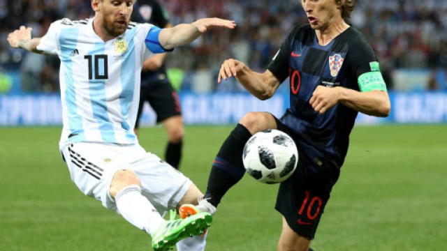 Modric, talento croato, impegnato in un contrasto con Lionel Messi.